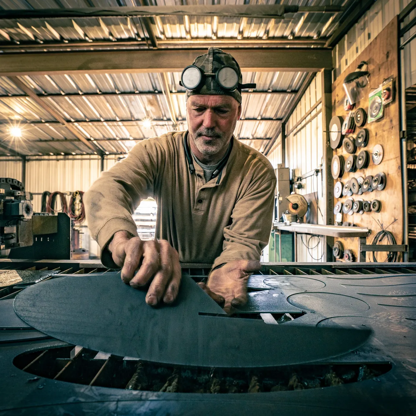 John T. Benedict at his cutting table, a cut steel sheet in front of him