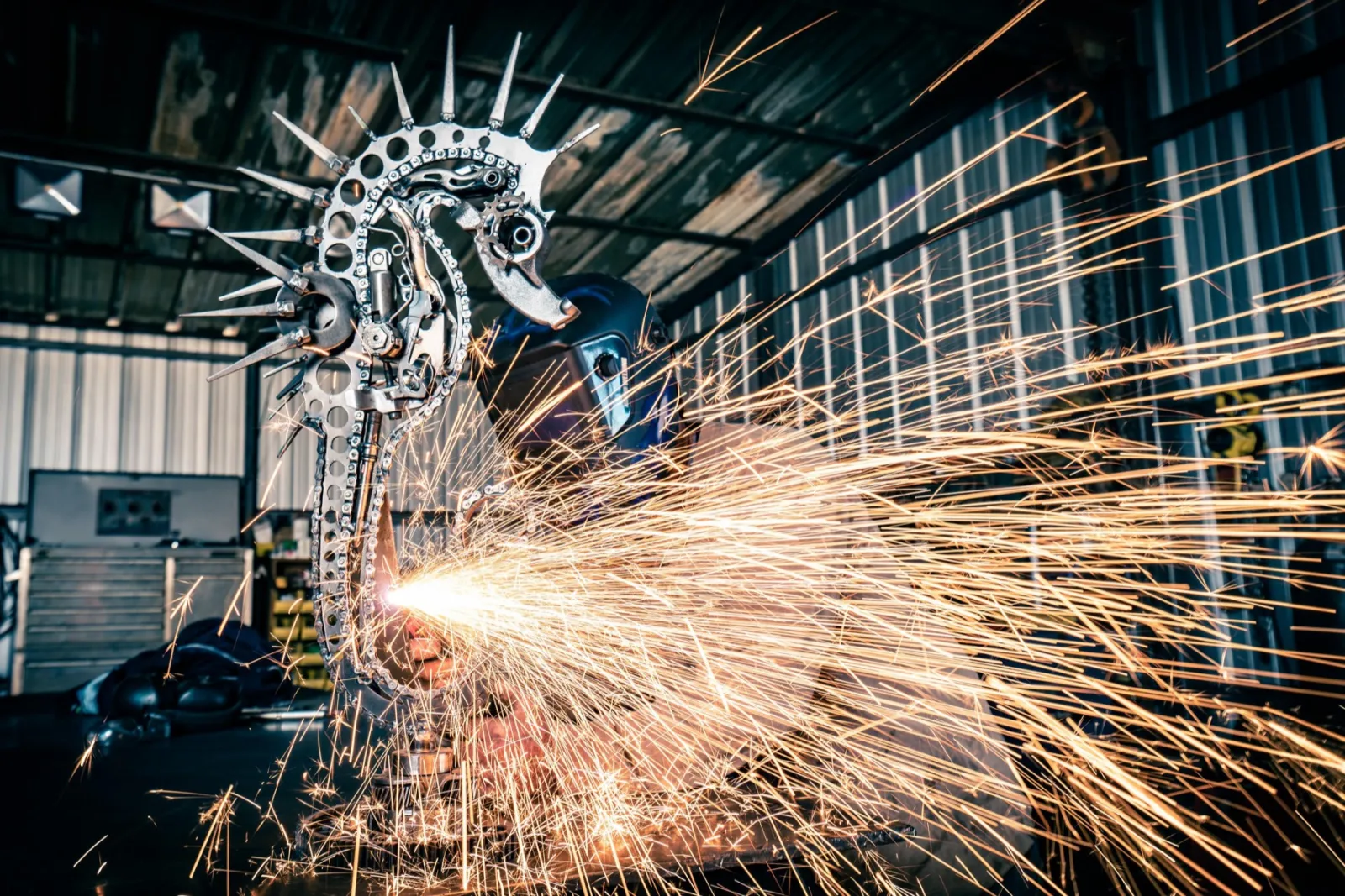 A steel seahorse sculpture in a shower of sparks