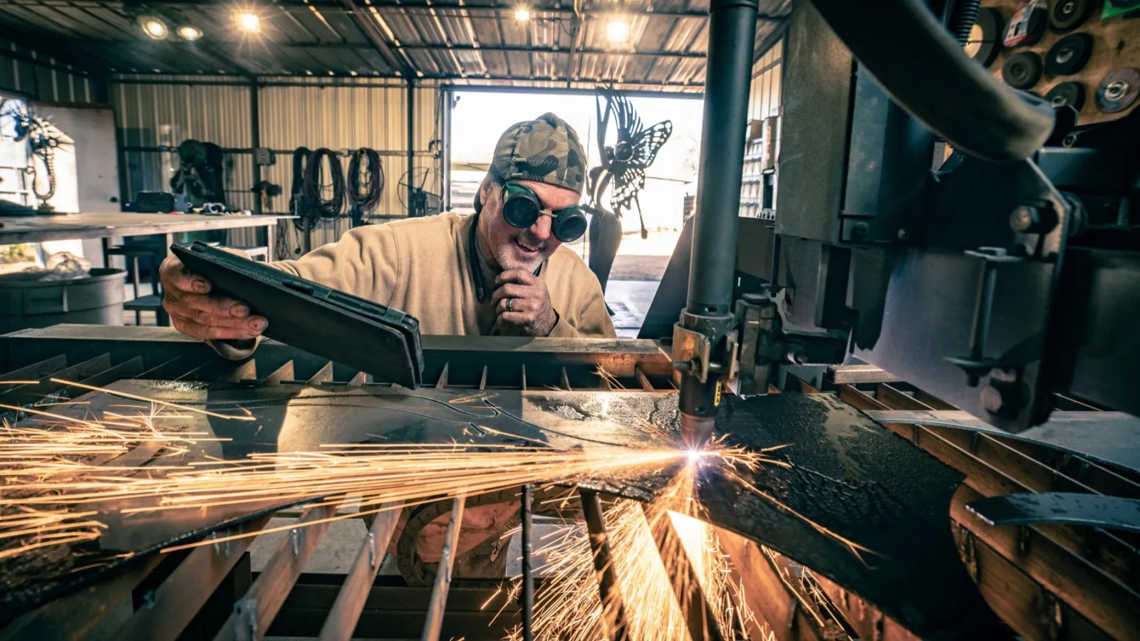 John smiling behind a plasma table as sparks fly in his Tucson studio